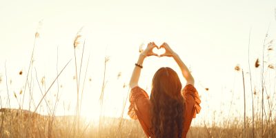 Woman in a summer field. Brunette in a yellow skirt. Girl on a sunset background.
