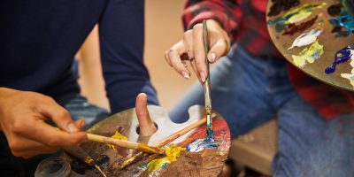 Woman and man mix oils on a palette