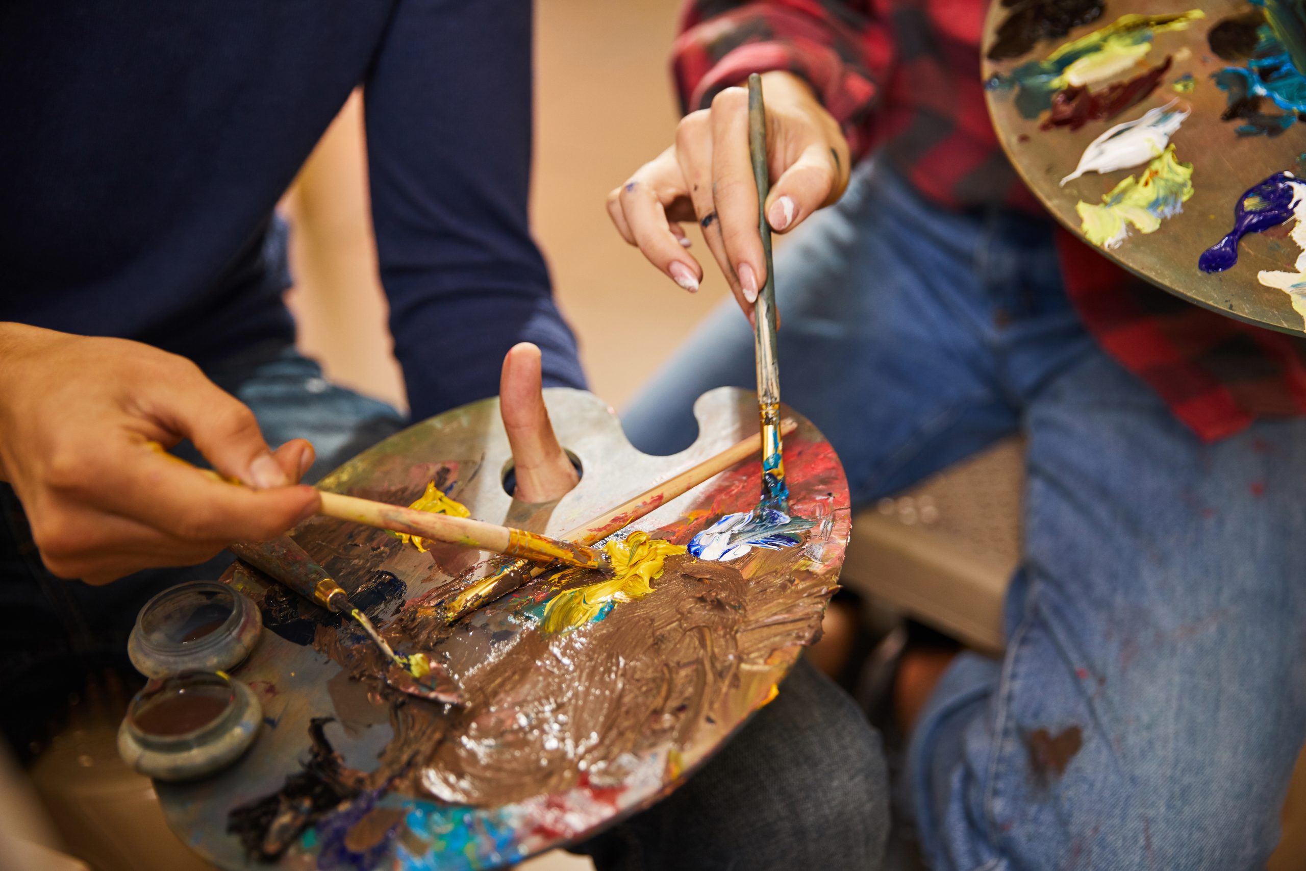 Woman and man mix oils on a palette